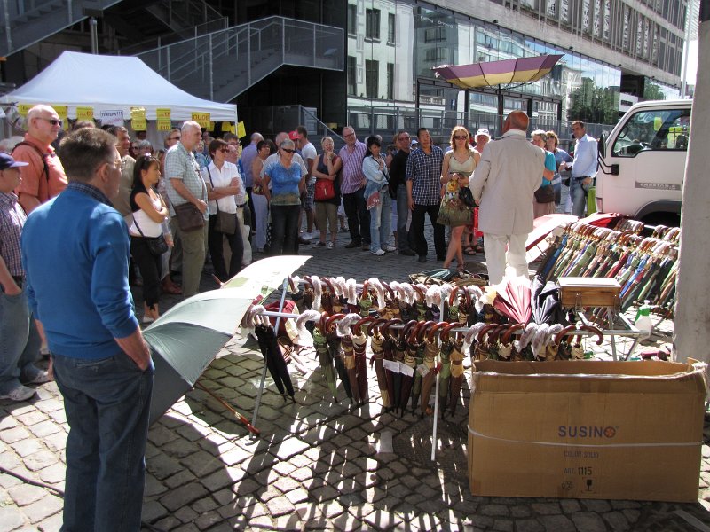 antwerpen28.JPG - Ook standwerkers vind je op de vogeltjesmarkt. Deze meneer brengt zijn versie van de stormparaplu aan de man.