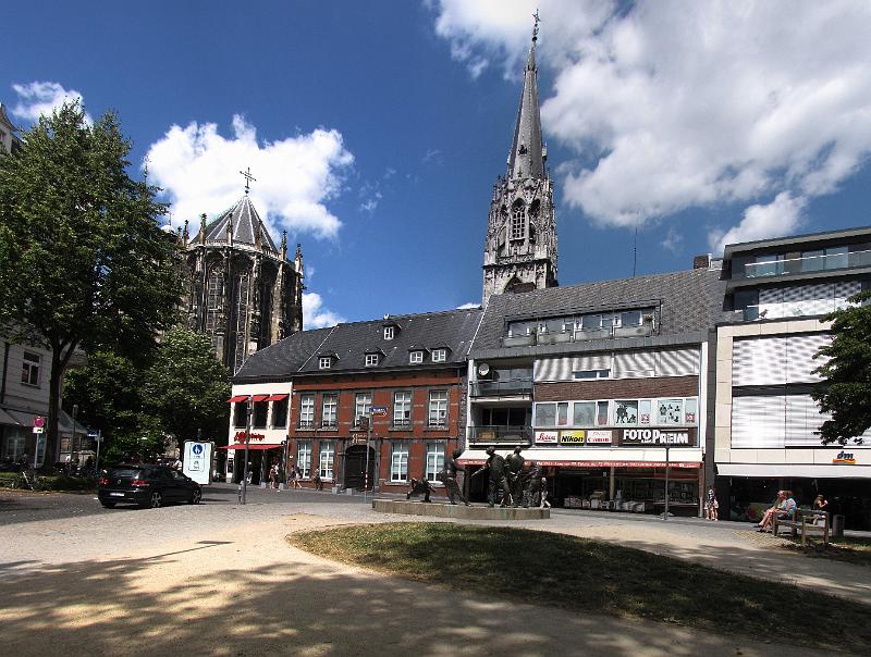aken_dom_en_winkels.jpg - Woensdag, we gaan met de bus naar Aken. Tussen Maastricht en Aken rijdt elk half uur een bus via Gulpen en Vaals naar het hoofdstation van Aken. Dat scheelt een parkeerplaats zoeken, dus we nemen lekker de bus. Op de foto één van de winkelstraten van Aken, met op de achtergrond de dom.