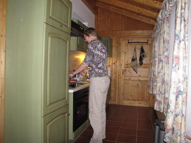 frouwkje_keuken.jpg - Frouwkje in de keuken. De keuken is voorzien van bloemetjes gordijnen. Een zeer kleurrijk geheel als de gordijnen gesloten zijn.