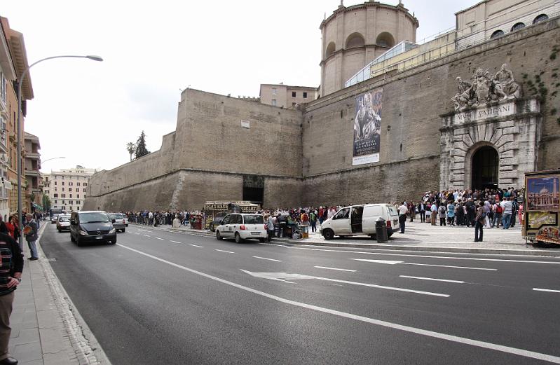 ingang_vaticaans_museum.jpg - Vrijdag stond een bezoek aan het Vaticaan en het Vaticaans museum op de planning. Op de foto de muren van Vaticaanstad en de ingang van Musei Vaticani.Tot onze schrik staan er twee enorme rijen. Één van mensen zonder reservering, maar ook één van mensen met een reservering. Al snel blijkt dat het museum een computerstoring heeft gehad, en dat het nog wel 3 tot 4 uur kan duren voordat we naar binnen kunnen. Gelukkig kunnen we onze reservering omzetten naar de zaterdag. We gaan vrijdag dus Rome verder verkennen.